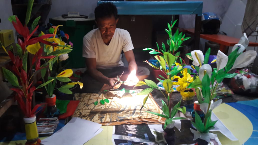 Abdullah Sedang Membuat Kerajinan Bunga Dari Kantong Plastik di Rumahnya. (Foto: Irham Banyuwangihits)